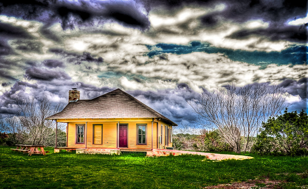 The historic farmhouse under a dramatic Texas sky
